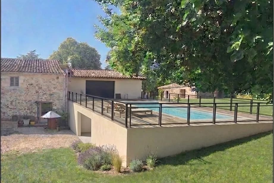 Terrasse et piscine installées devant la maison, sur un mur de soutènement